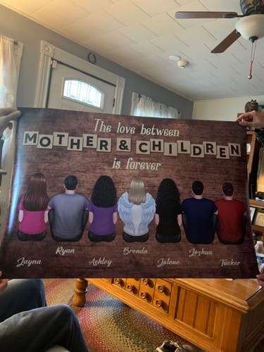 Reviewer holding a large, personalized 'Mother & Children' poster showing a mother and six children from behind.
