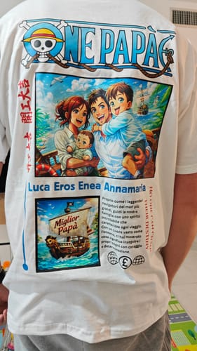 Rezensent zeigt die Rückseite seines personalisierten „One Papà“-T-Shirts mit buntem Anime-Druck.