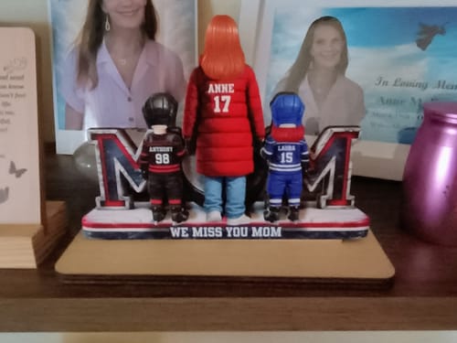 Customer's personalized hockey mom plaque on a memorial shelf, showing figures of a mom and two kids with text 'We Miss You Mom'.