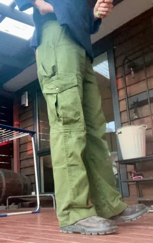 Customer's side view of the baggy, green Mid Rise Cargo Pants, highlighting the large cargo pocket.