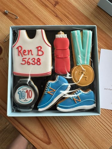 Customer's Running Biscuit Box, showing the personalized vest biscuit with 'Ren B 5638' and other themed cookies.