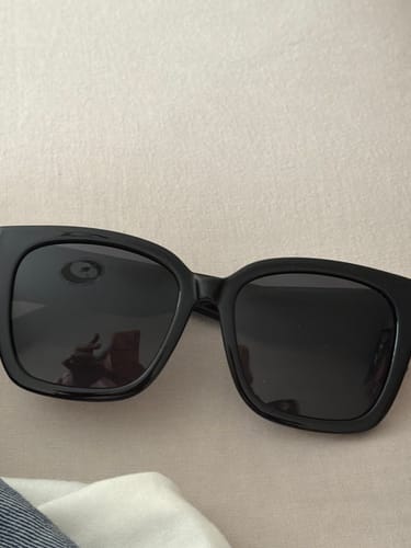 Customer's black, oversized Polarized Fit Over Sunglasses resting on a flat surface.