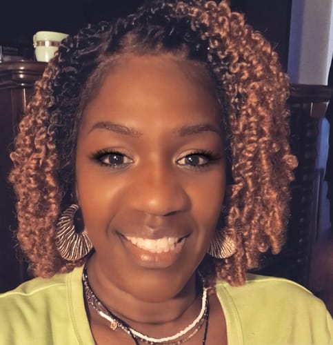Customer wearing a short, curly wig, showing the two-tone color and parting space.