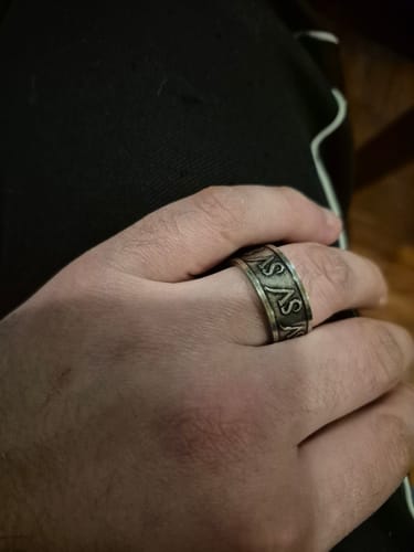 Primer plano del Anillo Iconic en la mano de un cliente, mostrando su grabado.