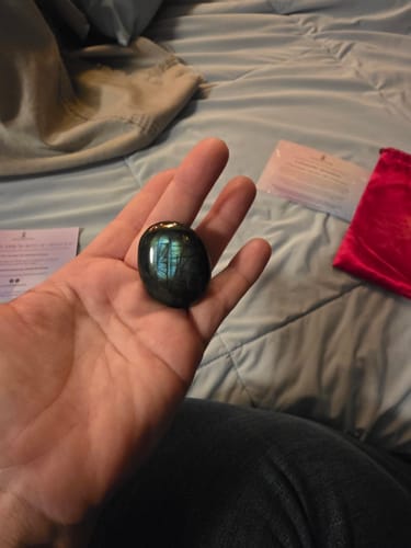 Customer holding the dark, polished Monthly Crystal in their palm to show its size.