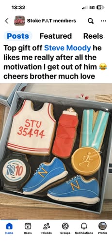 Customer's personalized Running Biscuit Box with decorated biscuits shaped as a vest, trainers, and a medal.