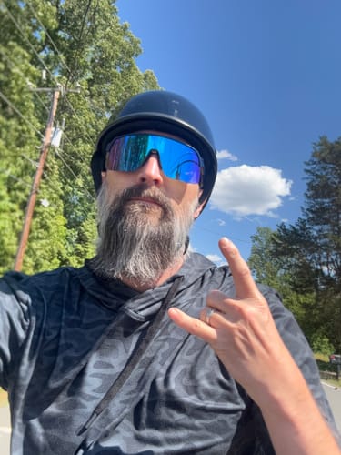Customer wearing the low-profile, black Switchback DOT Reversible Helmet outdoors on a sunny day.