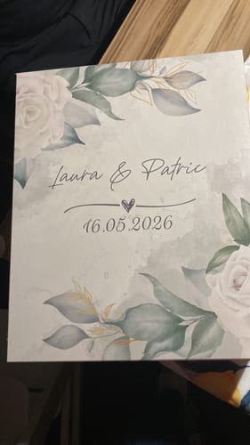 Kunde zeigt die personalisierte Holzkiste für die Leonardo Gläser mit Namen, Datum und Blumendesign.