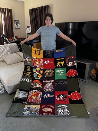 Customer proudly displaying their large Project Repat T-Shirt Quilt, made from many different t-shirts.