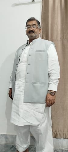 Reviewer standing in smart traditional attire.