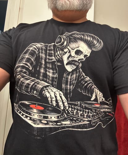 Customer wearing the black Los Vatos DJ T-Shirt, which features a large graphic of a skeleton DJing on turntables.