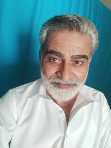 Reviewer for Sultan fragrance, a man with grey hair and beard in a white shirt.