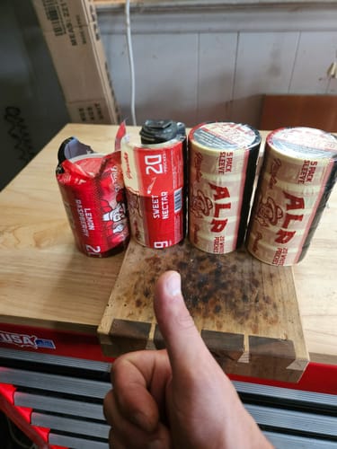 Customer giving a thumbs-up in front of several sleeves of Drifters nicotine pouches on a workbench.