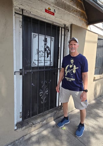 Reviewer wearing the navy blue Lincoln 250 T-Shirt in front of a storefront for Abe's on Lincoln.