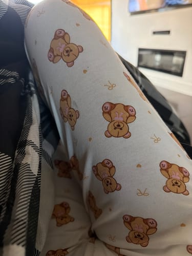 Customer wearing the Teddy Bear Pyjamas, in a close-up showing the teddy bear print on the soft white trouser fabric.