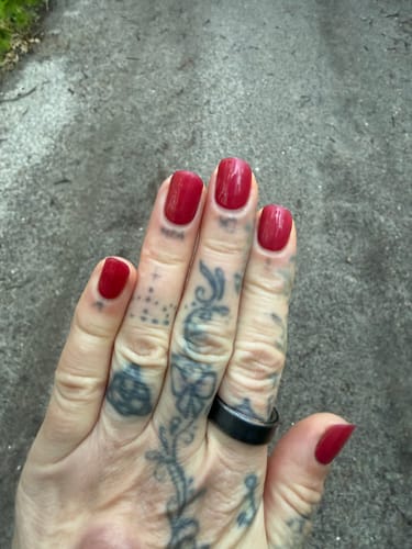 Kundenrezension: Nahaufnahme der roten 'Burning Lava' UV-Gel-Nagelfolien auf einer tätowierten Hand.