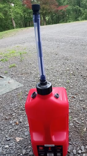 A customer's modified red 5 Gallon Jug with two PVC pipe fittings added to the top to hold the caps.