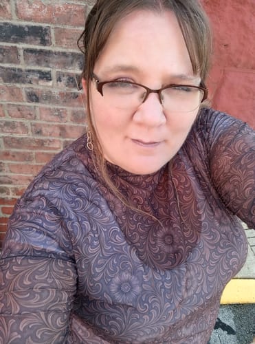 Customer's close-up wearing the sheer, patterned Bronzed Bloom Long Sleeve Mesh Top.