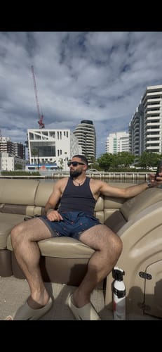 Customer wearing a black 340 Wife Lovers tank top while sitting on a boat.