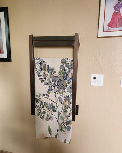 Customer's Flower Gauze Cotton Bath Towel with a floral pattern hanging on a dark wooden rack.