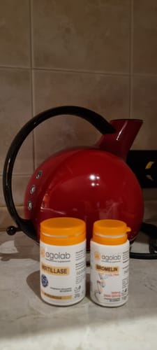 Recensore mostra i suoi integratori Agolab, Rutillase e Bromelin, su un bancone.