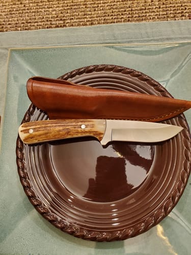 Reviewer's finished knife with an antler handle and leather sheath, made using the sanding belts.