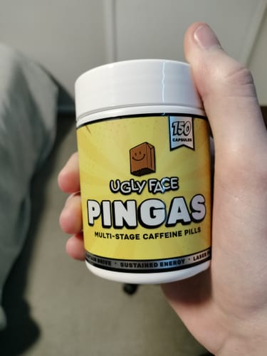 Customer holding a bottle of UGLYFACE PINGAS multi-stage caffeine pills.