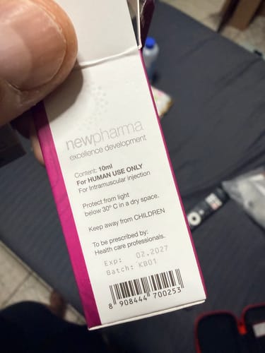 Primer plano de la caja de New Pharma Masteron Enantato 200mg sostenida por un cliente, mostrando los detalles del producto.