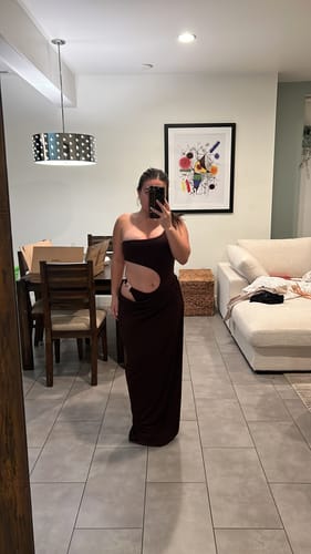 Reviewer taking a mirror selfie in the brown one-shoulder cut out maxi dress, showing the fit and waist cut-out.