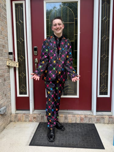Customer posing in the Halloween Colors Skull Bones suit. The black blazer and pants feature a colorful all-over skull pattern.