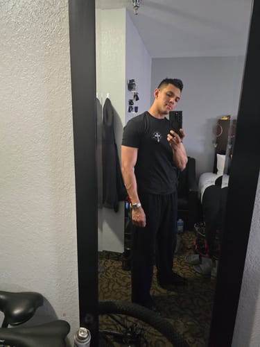 Reviewer taking a mirror selfie wearing the baggy, black Ember Sweats as a casual outfit.
