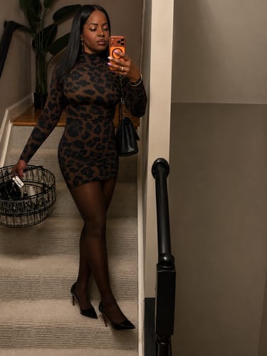 Customer wearing the long-sleeved, animal-print Naked Print Mini Dress while posing on a staircase.