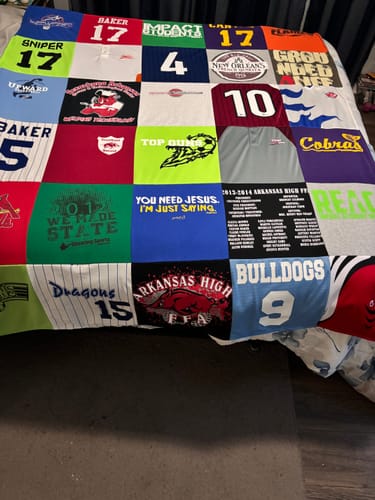 Customer's custom Project Repat T-Shirt Quilt showing a colorful patchwork of their son's sports and school shirts.