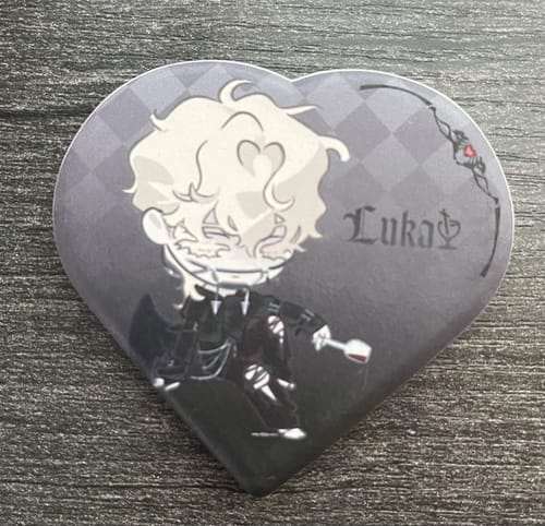 Customer's heart-shaped Alien Stage ceramic fridge magnet featuring the character Luka on a dark, patterned background.