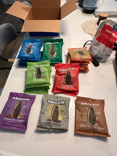 Reviewer's order of Smackin' sunflower seeds, with several colorful flavor bags displayed on a countertop.