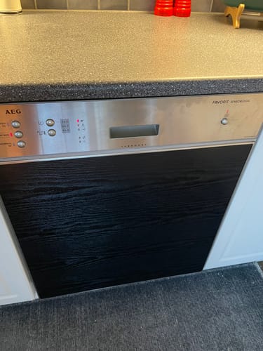 Anmelderens oppvaskmaskin dekket med svart Blackwood kontaktplast.