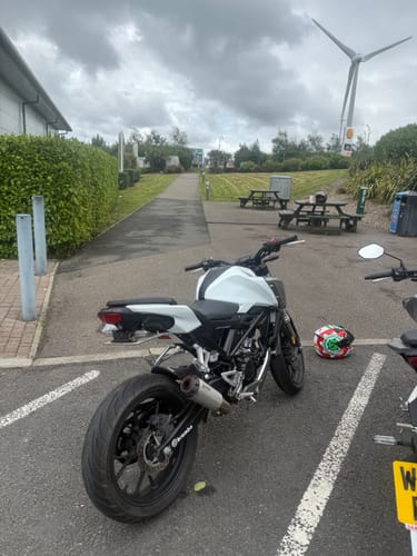 Reviewer's white Honda CB125R parked outdoors, showing the clean, minimal look from the installed tail tidy.
