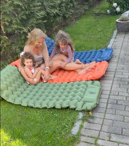 Family on three connected Adventure Mats on the lawn
