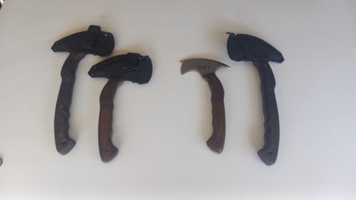 Reviewer's two 'Tahu' compact tomahawks shown next to two other tomahawks for comparison on a white surface.