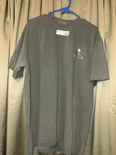 Customer's dark moss SlothHikingClub T-Shirt on a hanger, showing the muted graphic on the chest.