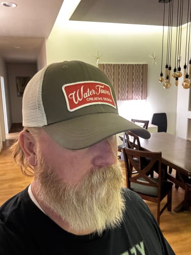 Reviewer wearing the olive green Big Trucker Hat with a white mesh back.