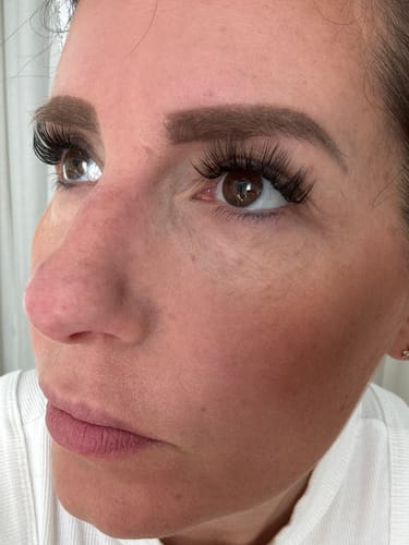 Nahaufnahme einer Kundin, die ihre langen, vollen Wimpern aus dem Classic DIY Starter Set nach neun Tagen Tragezeit zeigt.