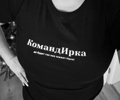 Close-up of a customer wearing the black Irina Tee with white Cyrillic text.