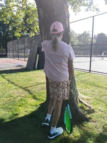 Reviewer at a tennis court wearing shoes used with their Extra Arch Support Insoles.