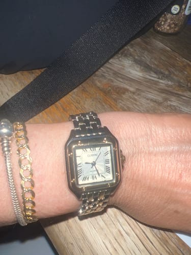 Customer wearing the classic two-tone GREALY DE MAINS watch on their wrist, styled with other bracelets.