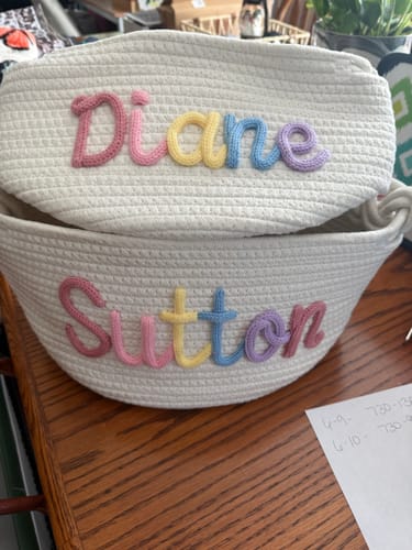 Customer's two personalized white baskets with the names 'Diane' and 'Sutton' in colorful yarn.