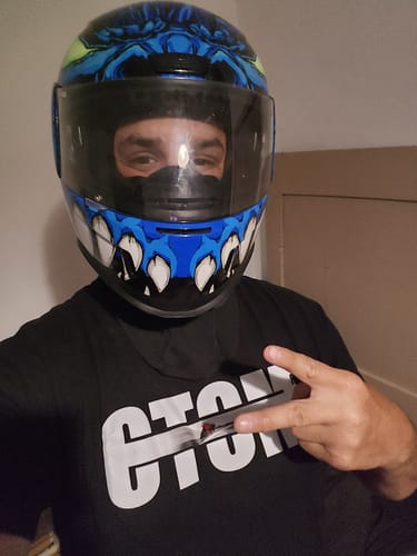 Client portant un t-shirt noir de la COLLECTION PRISMA avec un casque de moto.