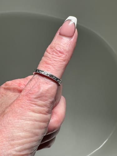 Close-up of a reviewer wearing the vintage art deco wedding band as a thumb ring.