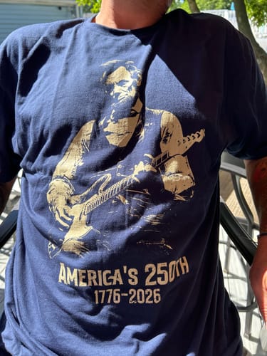 Reviewer wearing the navy blue Lincoln 250 T-Shirt, showing the graphic of Abraham Lincoln playing a guitar.