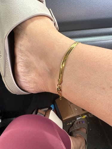 Customer wearing the gold Angelica® Stainless Steel Herringbone Bracelet as an anklet while in a car.